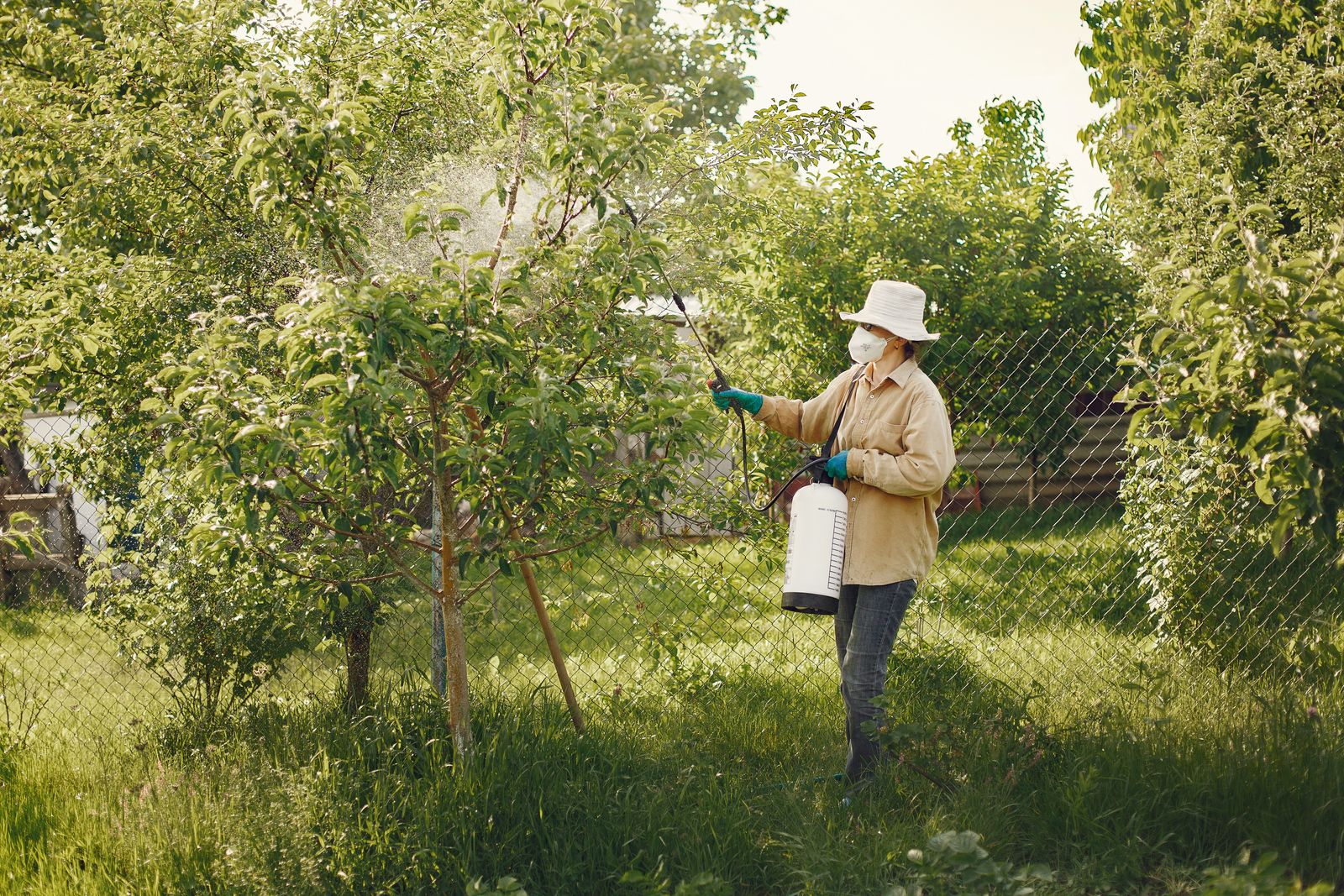 A Summit Pest Control technician in protective gear treating the exterior of a Southern Utah home